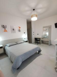 a white bedroom with a large bed and a desk at Angela's House in Alessandria +27 photos