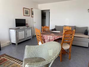 ein Wohnzimmer mit Tisch und Stühlen und einer Couch in der Unterkunft La Corniche in Agon Coutainville