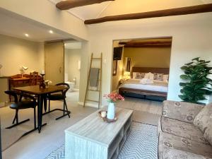 a living room with a bed and a couch and a table at Rosebud Cottages in George
