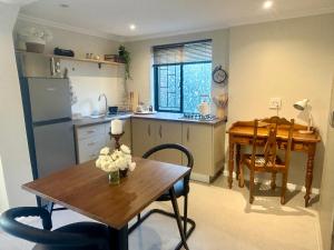 a kitchen with a wooden table and a dining room at Rosebud Cottages in George