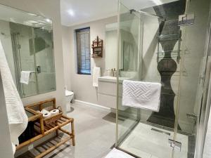 a bathroom with a glass shower and a sink at Rosebud Cottages in George +38 photos