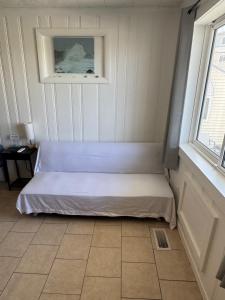 a small bed in a room with a window at North Beach Motel in Hampton