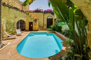 an outdoor swimming pool in the yard of a house at Serene Escape Farmhouse B&B in San Katald