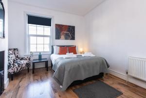 una camera da letto bianca con un letto e una finestra di Spacious 5BR House in Central Derby - Near Amenities a Derby
