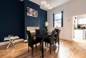 una sala da pranzo con tavolo nero e sedie nere di Spacious 5BR House in Central Derby - Near Amenities a Derby Altre 10 foto