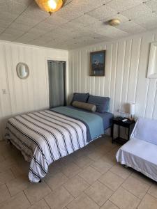 a bedroom with a bed and a bedskirtspectspectssenalsenalsenalsenalsenal at North Beach Motel in Hampton