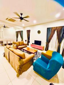 a living room with couches and a ceiling fan at Camelia Homestay in Melaka