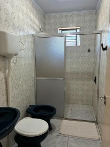 a bathroom with a shower and a toilet and a sink at Hotel Comodoro De Livramento in Santana do Livramento +36 photos