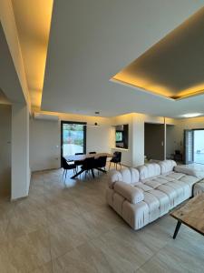 a living room with a large couch and a table at White Sand Loutraki Villa - Sea View in Loutraki