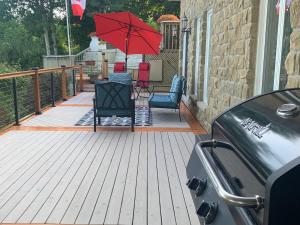 a deck with chairs and a red umbrella at Q Estate Guest Suite heated indoor pool in Westport