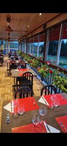 un ristorante con tavoli con tovaglioli rossi e bicchieri da vino di Hôtel Restaurant du Lac a Camps