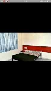 a bedroom with a green bed and a window at SAIRATNA HOTEL only 1 minute distance from sai temple in Shirdi