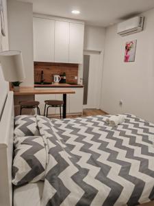 a bedroom with a bed and a kitchen at Pe Pe room in Našice +3 photos