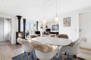 un soggiorno con tavolo, sedie e camino di 257-Ringkobing-Lyngvejen-3 a Ringkøbing