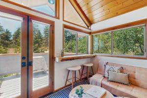 a screened in porch with a couch and windows at Deerhaven Lodge B in Idyllwild