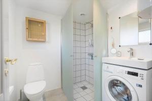 a bathroom with a washing machine and a toilet at 172-Ringkobing-Magedalen-34 in Ringkøbing +25 photos