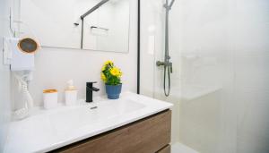 ein weißes Badezimmer mit Waschbecken und Dusche in der Unterkunft Exclusive Luxury Comfort Stay - Malaga Center in Málaga
