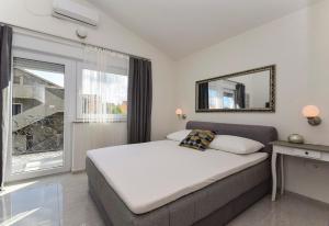 een slaapkamer met een bed met een spiegel en een raam bij Mary Rose in Vodice +63 foto's