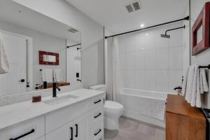 a bathroom with a sink and a toilet and a tub at Harrison Hot Springs Lakeside in Harrison Hot Springs +17 photos