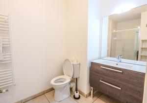 ein Badezimmer mit Toilette, Waschbecken und Spiegel in der Unterkunft Appartement Villa Losa in Biscarrosse