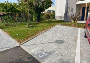 ein Parkplatz mit einem in einer Einfahrt geparkten Auto in der Unterkunft Appartement Villa Losa in Biscarrosse