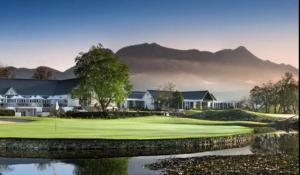 a view of a golf course with mountains in the background at Rosebud Cottages in George