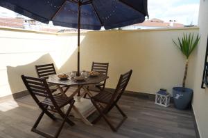 a table with chairs and an umbrella on a patio at CatMandu Oldstation in Amarante