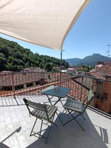 Una mesa y dos sillas sentadas en un balcón. en Ca' Ma' Holiday Lecco Lake Como, en Lecco