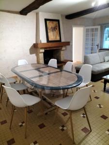 a dining room with a table and chairs and a couch at Indivision Bernard Pillaud in Chantonnay