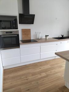 a kitchen with white cabinets and a microwave at Indivision Bernard Pillaud in Chantonnay +7 photos
