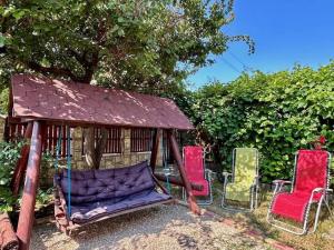 a group of chairs and a swing in a gazebo at Maty's House in Schitul