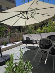 a patio with two chairs and an umbrella at MoonLight Lofts APHRODITE & POSEIDON in Alexandroupoli