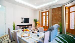 a dining room with a table and a couch at Luxury Views Plaza Constitución - Executive Malaga Center in Málaga