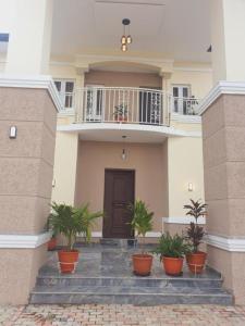 a building with potted plants in front of a door at Suris 1 bedroom luxury in Abuja +12 photos