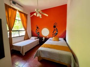 a bedroom with two beds and a red wall at Siwõ Art Guesthouse in Ocotal