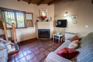 a living room with a couch and a fireplace at Casa Rural El Pilar in Acebo