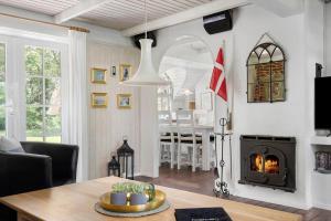 un soggiorno con tavolo e camino di 123-Ringkobing-Granalle-3 a Nørby