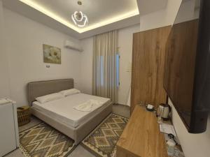 Un pequeño dormitorio con una cama y un televisor. en Lalun, en Golem 73 fotos más