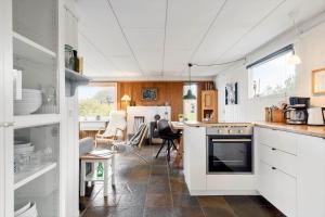una cucina con mobili bianchi e un piano di lavoro di 1083-Ringkobing-Spaettedalen-6 a Nørby