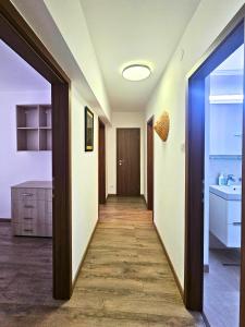 a hallway leading to a bathroom with a sink at Fancy 3BD Family Friendly in Historical Centre Netflix View in Bucharest