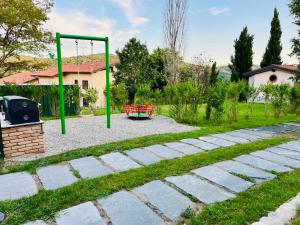 un parque infantil con un columpio en un patio en Il Gelsomino - Terrace Country House, en Pisano
