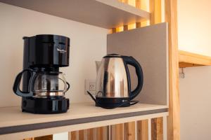 a coffee maker and a blender on a shelf at Los Cardos Lodge & Glamping in Malargüe