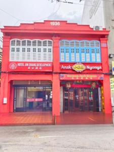 a red building on a street corner with avertisement at Guan Gong Hotel Jin Shang Development Jonker Street in Malacca