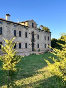 an old stone building on a grassy field at Locanda Corte Arcangeli in Ferrara +56 photos