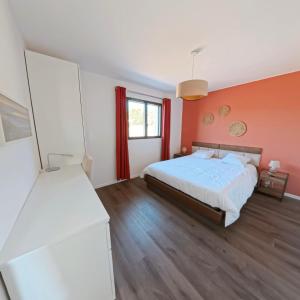 - une chambre avec un lit et un mur orange dans l'établissement Villa Chrisaline, Centre Moliets, 3 chambres parentales, 10-15 personnes, équipements premium, à Moliets-et-Maa