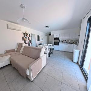 un salon avec un canapé et une cuisine dans l'établissement Villa Chrisaline, Centre Moliets, 3 chambres parentales, 10-15 personnes, équipements premium, à Moliets-et-Maa 31 autres photos