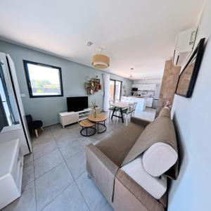 un salon avec un canapé et une table dans l'établissement Villa Chrisaline, Centre Moliets, 3 chambres parentales, 10-15 personnes, équipements premium, à Moliets-et-Maa