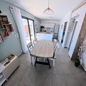 une cuisine et une salle à manger avec une table et des chaises dans l'établissement Villa Chrisaline, Centre Moliets, 3 chambres parentales, 10-15 personnes, équipements premium, à Moliets-et-Maa