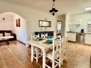 a kitchen and dining room with a white table and chairs at Villa Morriña by Vulcano Homes in Playa Honda +19 photos