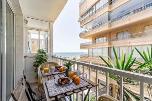 a balcony with a table with oranges on it at Exclusive Deluxe Apartment - Fuengirola Beachfront in Fuengirola